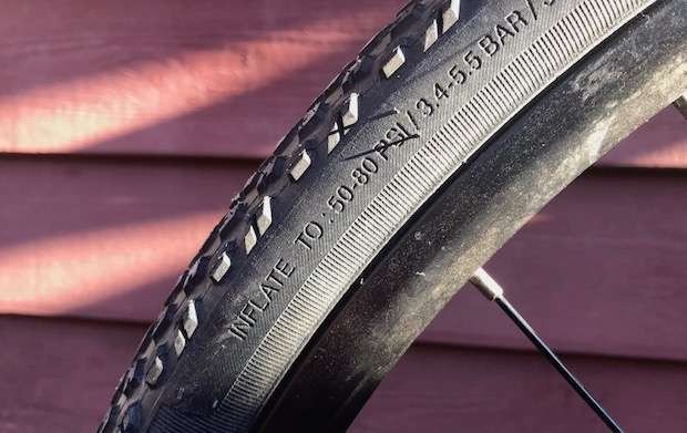 raised lettering on side of a bike tire showing the recommended air pressure