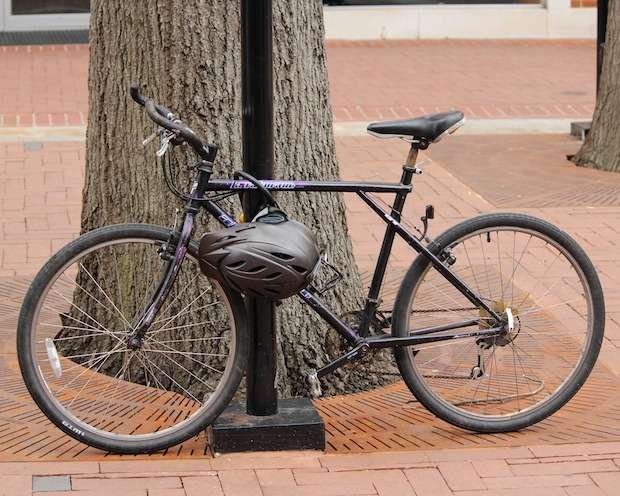 Locked bicycle with a helmet hanging from the frame