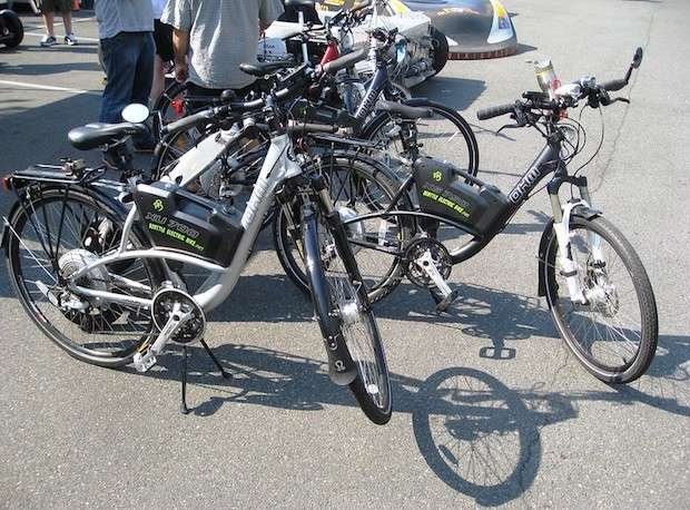 Two electric bikes parked among other bikes