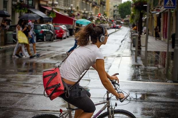 Cyclist with headphones covering her entire ear