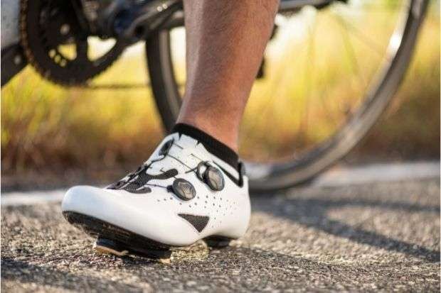 Cyclist in road cycling shoes with foot planted on ground