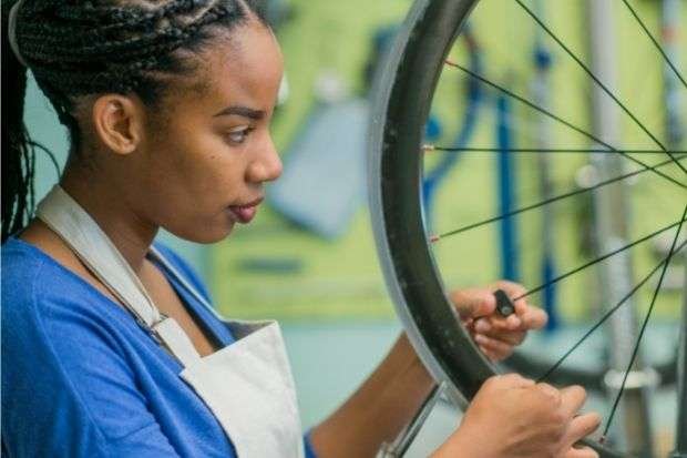 Bike mechanic does a repair so the rider won't have to ride with a broken spoke