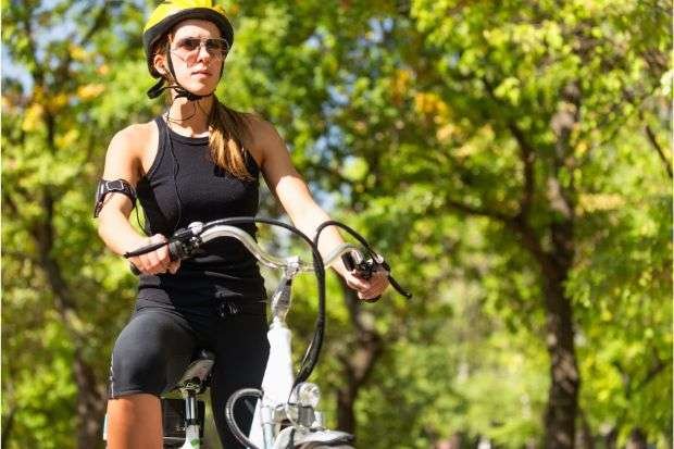 The Best Bike Helmets for Ponytails Out There Woman on bike and wearing bike helmet for ponytails
