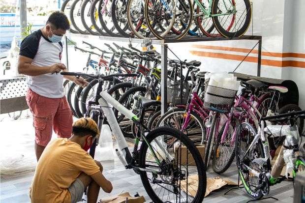 Carbon or Aluminum Mountain Bike: Which Should You Buy? Bike mechanics assembling bike at bike shop where you can buy carbon or aluminum mountain bikes